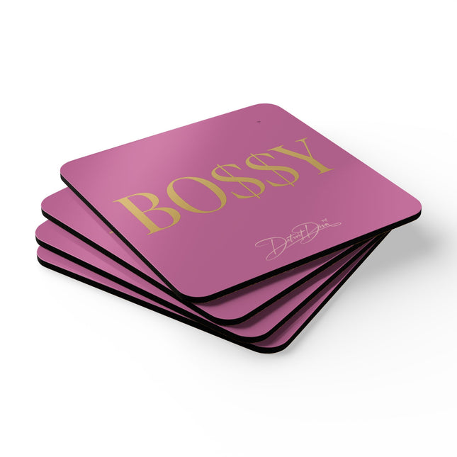 Stack of pink coasters with 'BOSSY' in gold text on a white background