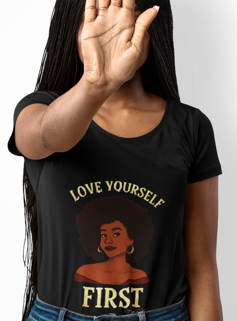 Person wearing a black t-shirt with 'Love Yourself First' text and graphic design.