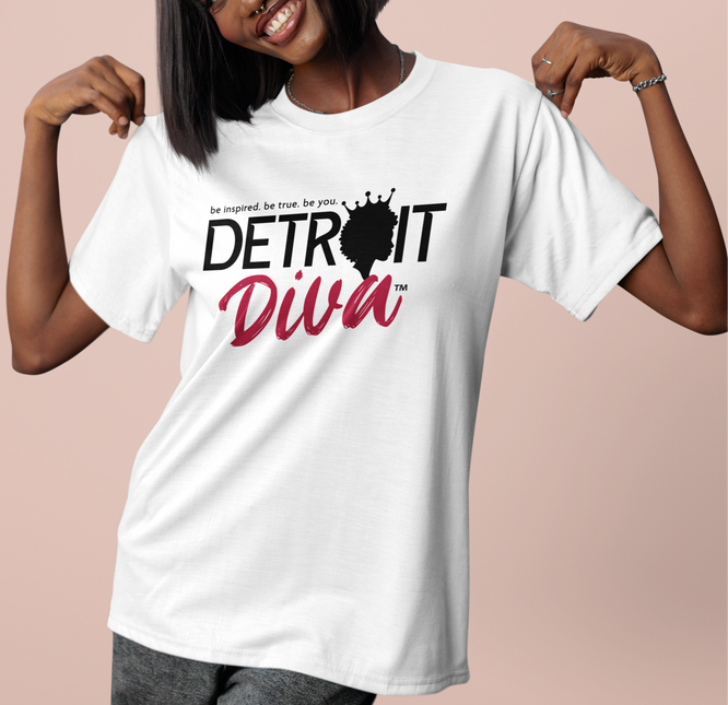 Woman wearing a white t-shirt with 'Detroit Diva' design on a pink background