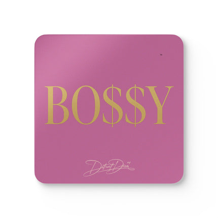 Pink mouse pad with 'BOSSY' in gold letters and a signature logo on a white background