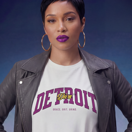 Woman wearing a white t-shirt with 'Detroit' text against a gradient blue background